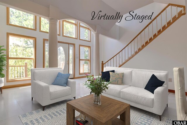1219 Bismark Dr Lot # 107, Corolla, NC 27927 - living area with decorative columns, stairway, and a towering ceiling