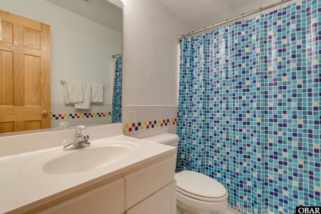 1219 Bismark Dr Lot # 107, Corolla, NC 27927 - bathroom featuring tile walls, vanity, a wainscoted wall, and curtained shower