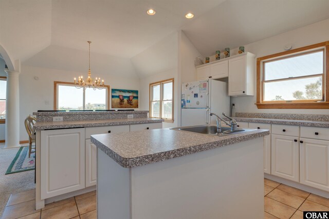 1219 Bismark Dr Lot # 107, Corolla, NC 27927 - kitchen featuring a kitchen island with sink, freestanding refrigerator, lofted ceiling, plenty of natural light, and light tile patterned flooring