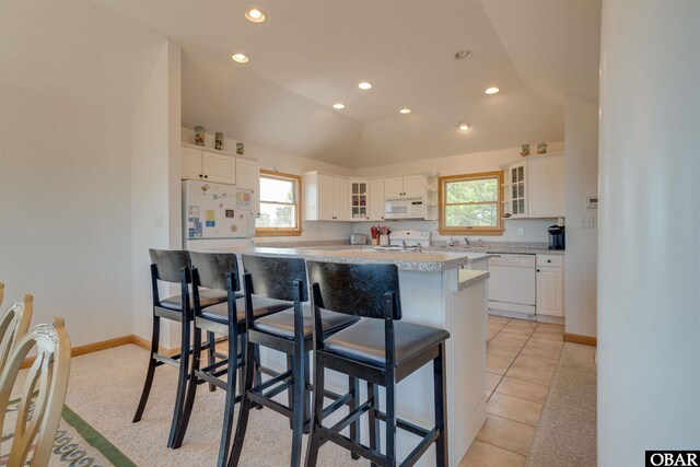 1219 Bismark Dr Lot # 107, Corolla, NC 27927 - kitchen featuring white appliances, recessed lighting, white cabinets, glass insert cabinets, and a kitchen bar