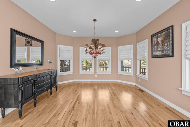 dining area featuring a notable chandelier, light wood-style floors, and baseboards