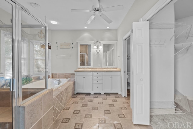 bathroom featuring a sink, double vanity, a garden tub, and a shower stall