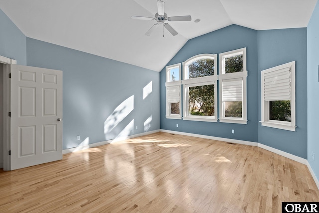 interior space featuring visible vents, light wood-style flooring, a ceiling fan, vaulted ceiling, and baseboards