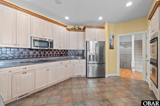 kitchen featuring visible vents, decorative backsplash, appliances with stainless steel finishes, dark stone countertops, and recessed lighting