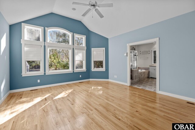 unfurnished bedroom with vaulted ceiling, baseboards, visible vents, and light wood-style floors