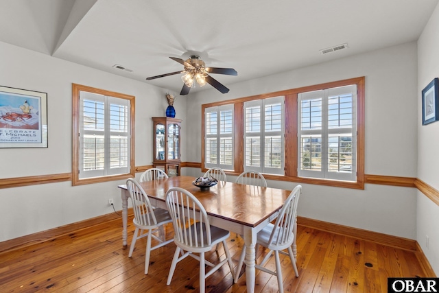 dining room featuring light wood-style flooring, plenty of natural light, and visible vents