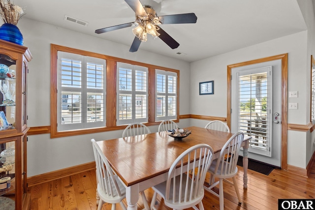 dining room with light wood-type flooring, visible vents, baseboards, and ceiling fan