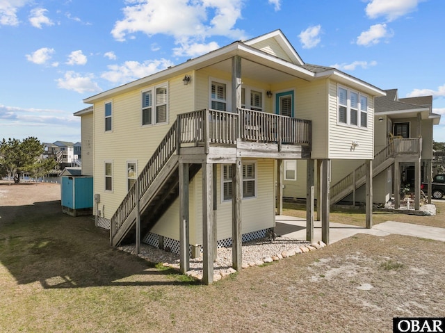 rear view of property with stairs and a carport