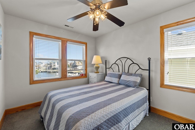 carpeted bedroom featuring visible vents, baseboards, and a ceiling fan