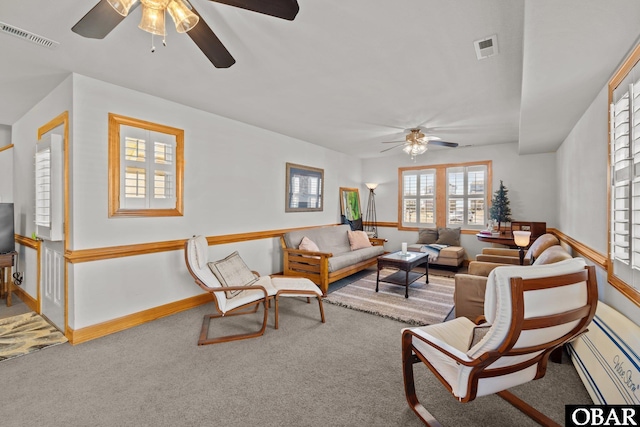 living room with carpet, baseboards, a ceiling fan, visible vents, and a baseboard radiator