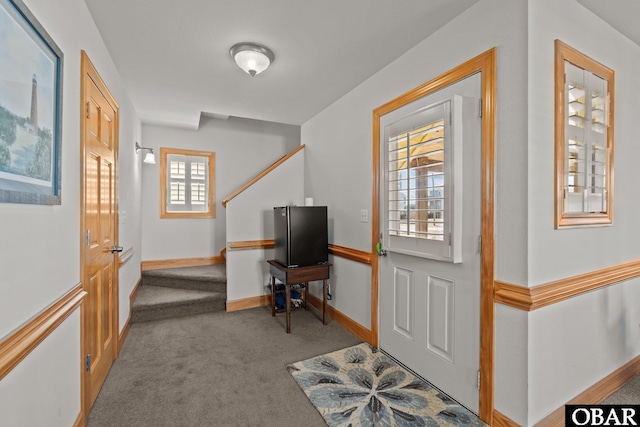 entrance foyer with baseboards, carpet floors, and stairs