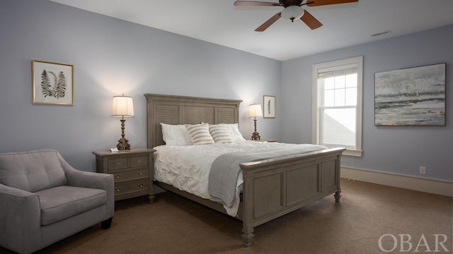 bedroom featuring dark colored carpet, ceiling fan, and baseboards