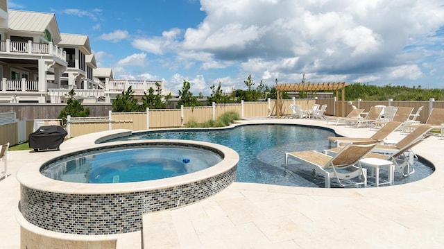 view of pool featuring a pool with connected hot tub, a patio, and fence