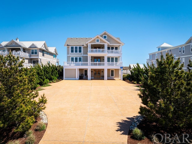 coastal inspired home featuring board and batten siding, a residential view, and a balcony