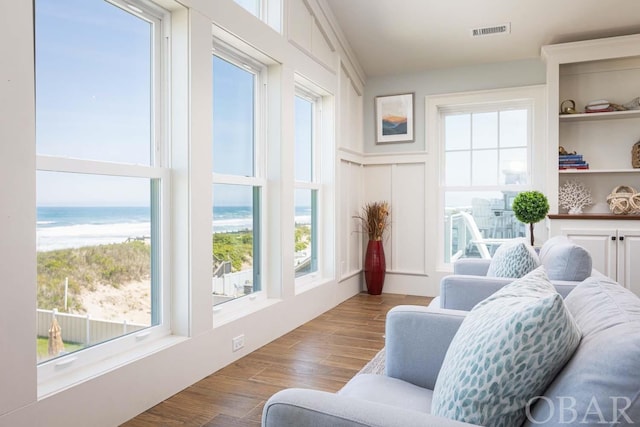 sunroom featuring a water view, a healthy amount of sunlight, and visible vents