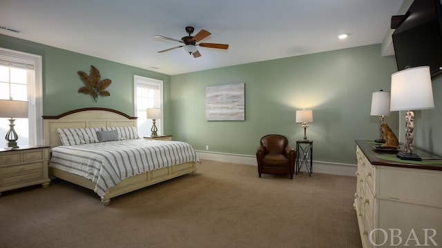 bedroom with ceiling fan, carpet floors, visible vents, and baseboards