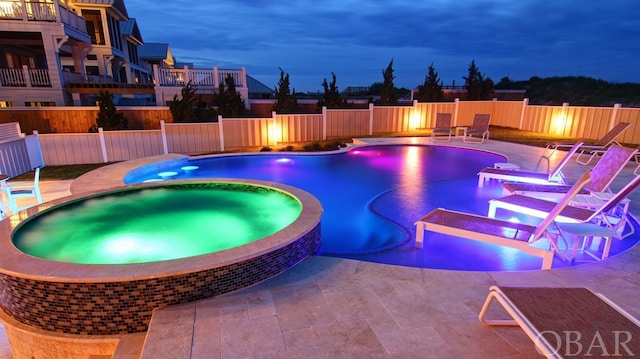 view of swimming pool with a pool with connected hot tub, a patio area, and a fenced backyard