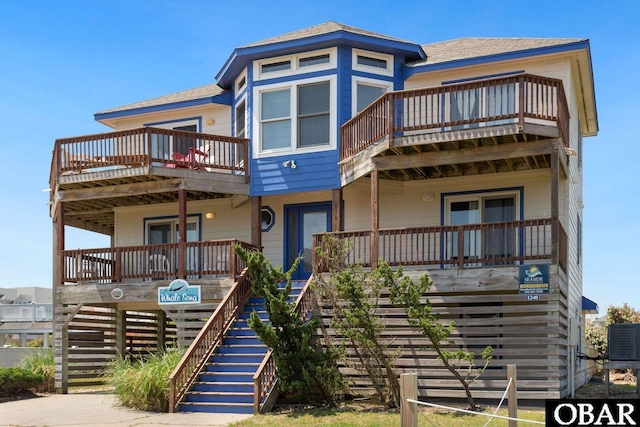 view of front of home featuring stairs, cooling unit, and a balcony