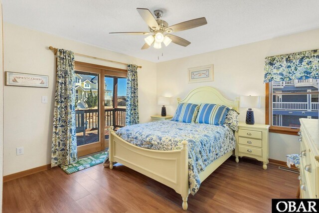 bedroom with access to outside, dark wood-style flooring, and baseboards