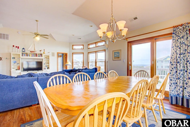 dining area with visible vents, wood finished floors, and ceiling fan with notable chandelier