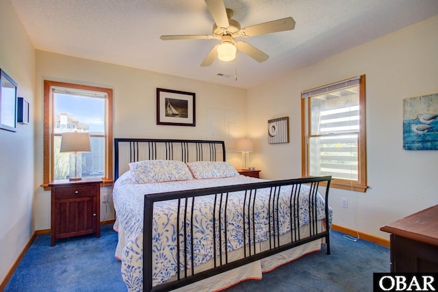 bedroom with baseboards, dark carpet, and a textured ceiling