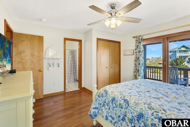 bedroom featuring a textured ceiling, ensuite bath, wood finished floors, access to outside, and baseboards