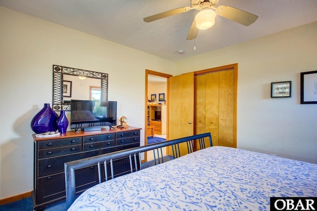 bedroom with a closet, ceiling fan, a textured ceiling, and baseboards