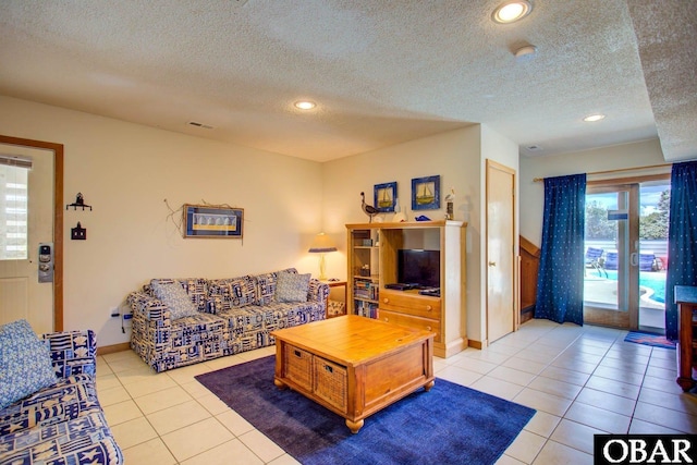 living room featuring light tile patterned floors, baseboards, a textured ceiling, and recessed lighting