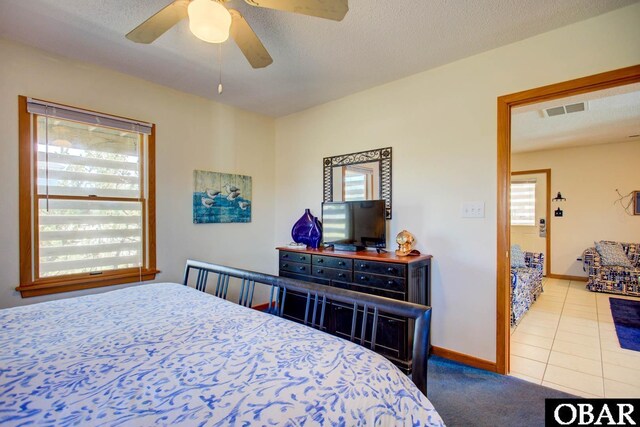 bedroom featuring visible vents, a textured ceiling, baseboards, and tile patterned floors