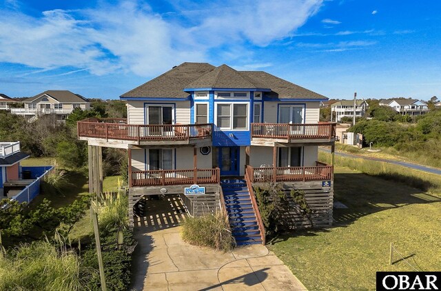 back of house with a deck, a shingled roof, and a residential view