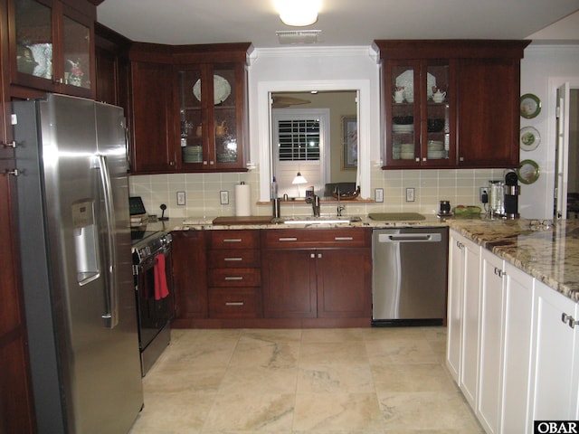 kitchen with ornamental molding, stainless steel appliances, dark brown cabinets, and backsplash