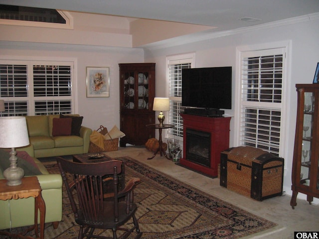 living area with a fireplace, visible vents, and ornamental molding