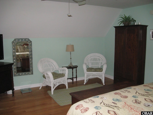 bedroom with baseboards, vaulted ceiling, and wood finished floors