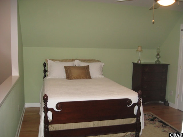 bedroom with vaulted ceiling, wood finished floors, a ceiling fan, and baseboards