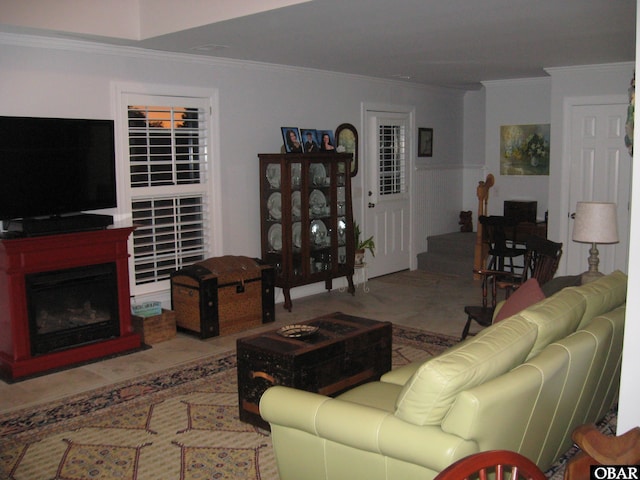 living area featuring a fireplace with flush hearth, stairway, and crown molding