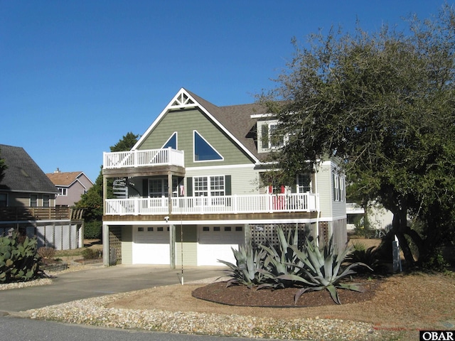 beach home with a garage, driveway, and a balcony