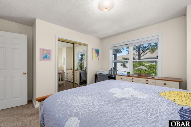 bedroom featuring baseboards, carpet, a closet, and a textured ceiling