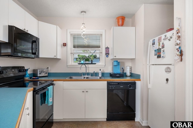 kitchen with a sink, white cabinets, pendant lighting, and black appliances