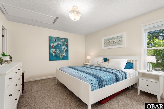 carpeted bedroom featuring baseboards, attic access, and a textured ceiling