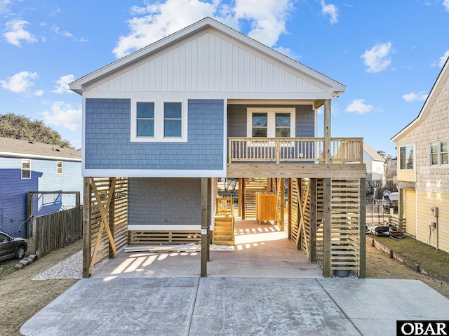 coastal inspired home with a carport, covered porch, and driveway