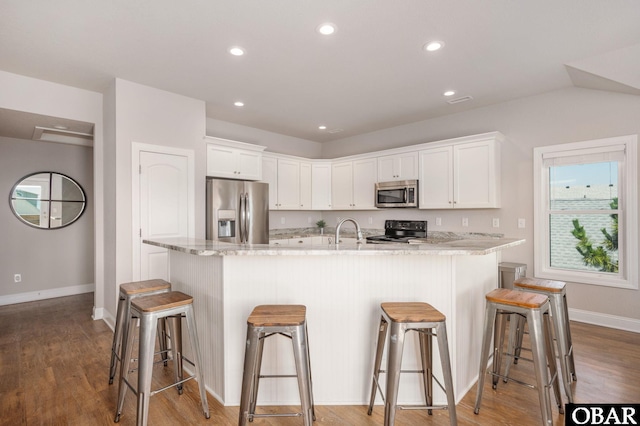 5009 Lindbergh Ave Lot 28, Kitty Hawk, NC 27949 - kitchen featuring stainless steel appliances, white cabinetry, recessed lighting, light stone counters, and a breakfast bar area