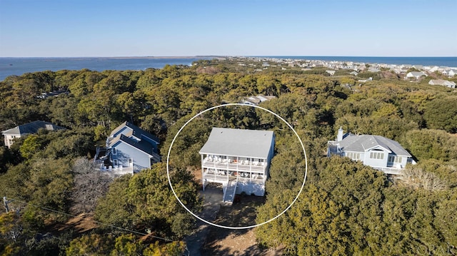 bird's eye view with a water view and a wooded view