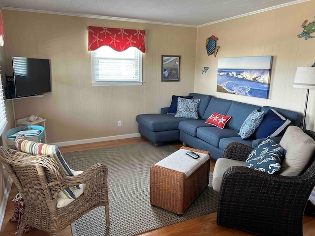 living area with baseboards, ornamental molding, and wood finished floors