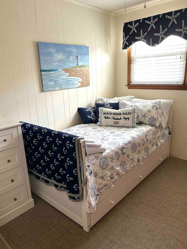 bedroom with ornamental molding and dark colored carpet