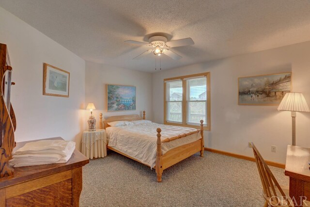 bedroom with a ceiling fan, carpet flooring, a textured ceiling, and baseboards