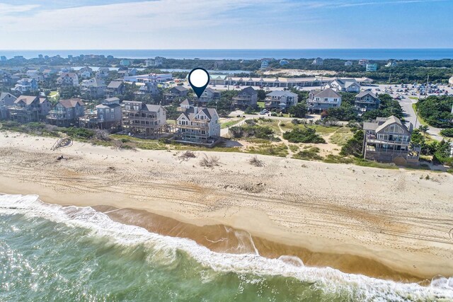 birds eye view of property with a water view and a beach view