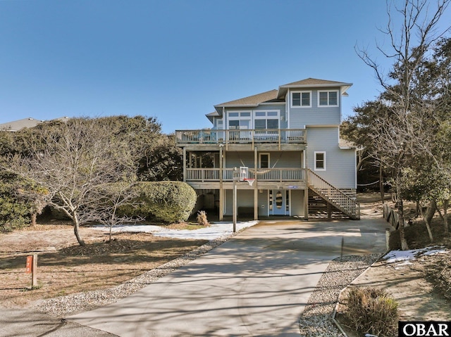 view of front of home featuring driveway, a balcony, and stairs