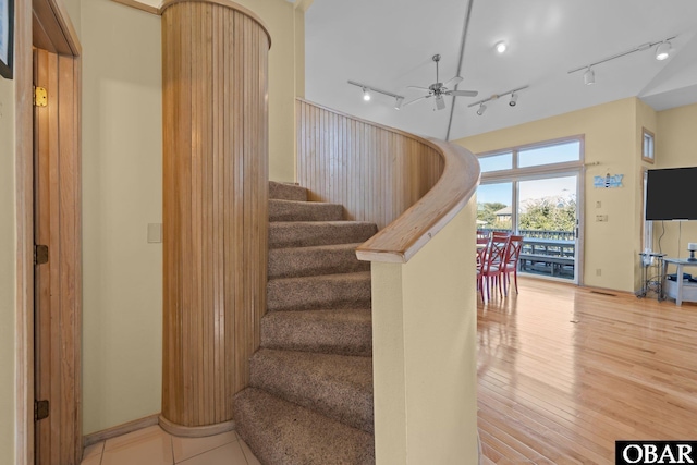 stairs with wood finished floors and a ceiling fan