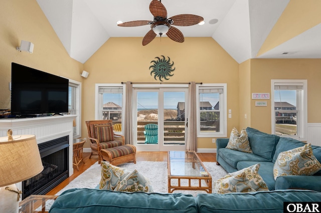 living room featuring vaulted ceiling, wood finished floors, a fireplace, and ceiling fan