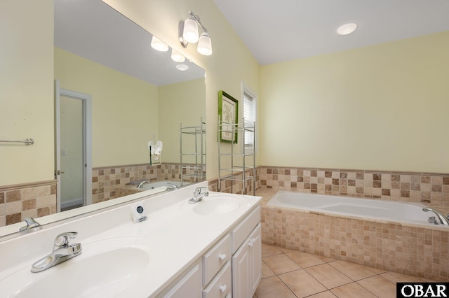 full bath featuring double vanity, a garden tub, tile patterned flooring, and a sink